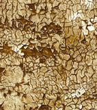 a close up of a cracked wall with gold paint
